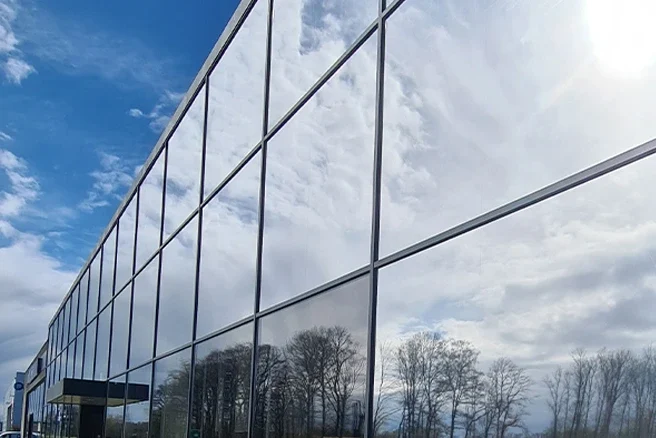 Glasgevel met spiegelende raamfolie voor zonwering en energie-efficiëntie
